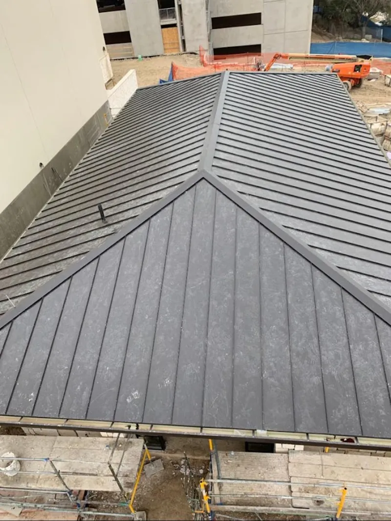 Commercial metal roof construction with crane equipment in Minooka